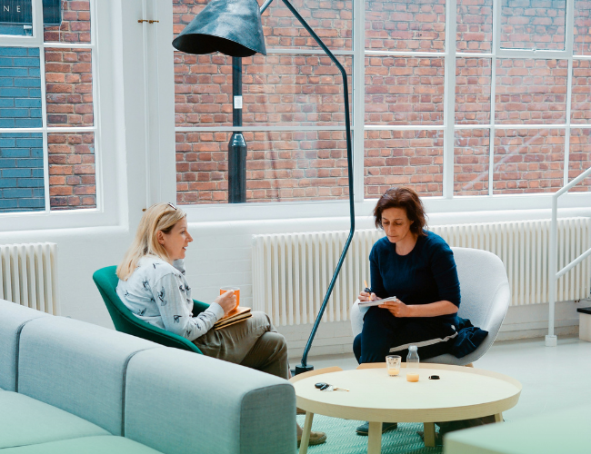 People meeting in open workspace with radiators behind them
